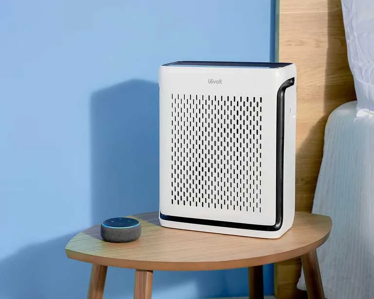 Purificatore d'aria Levoit Vital su un tavolino accanto al letto